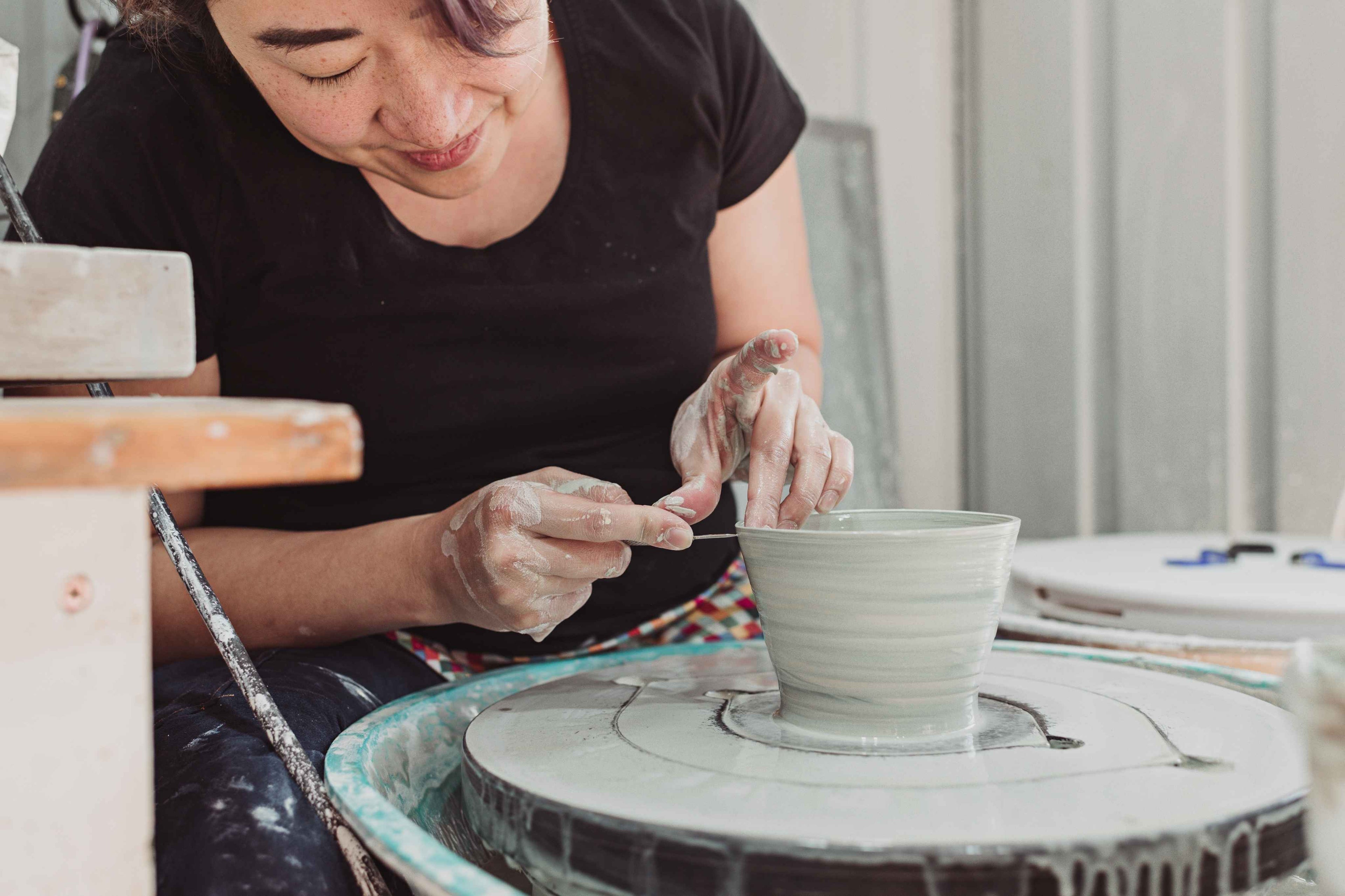 A woman making ceramic cups in her workshop